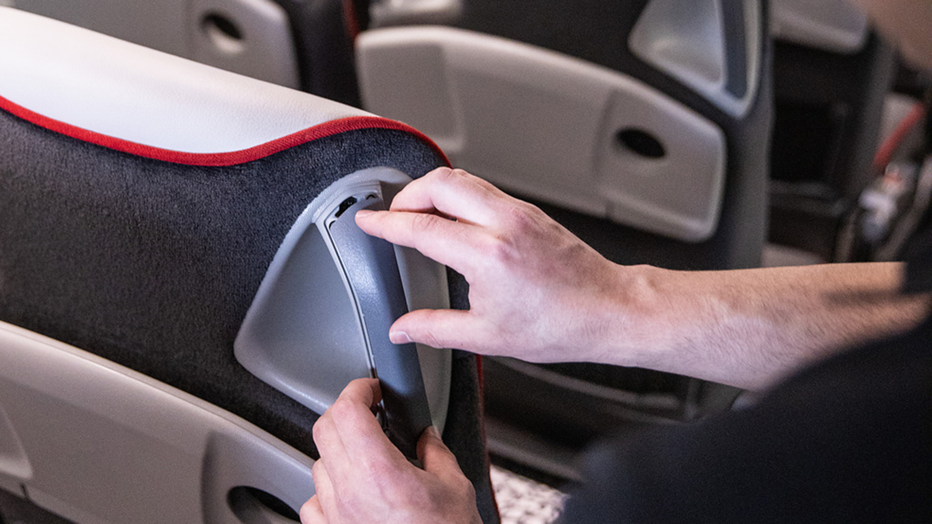 A 3D-printed handle insert is being applied to a seat. Image: Daimler Buses