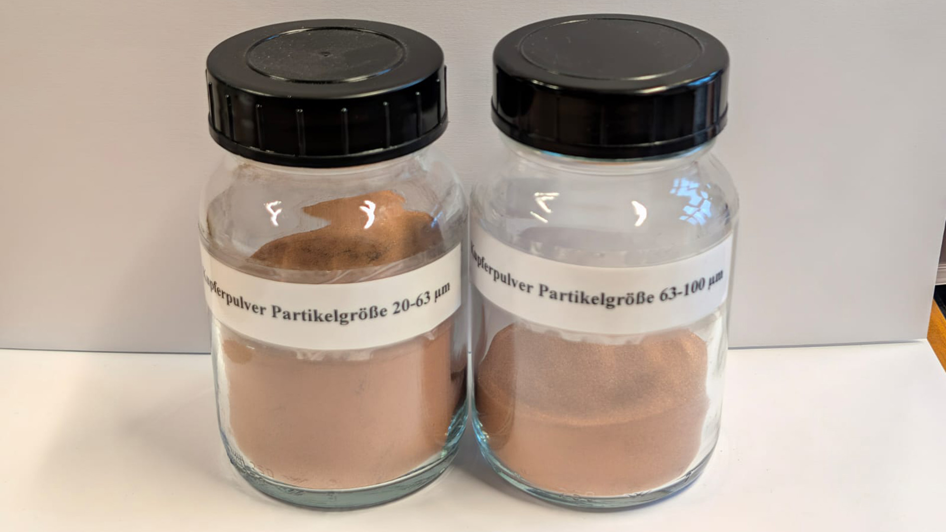 Fraktionen von recyceltem Kupferpulver mit Partikelgrößen von 20–63 µm und 63–100 µm.