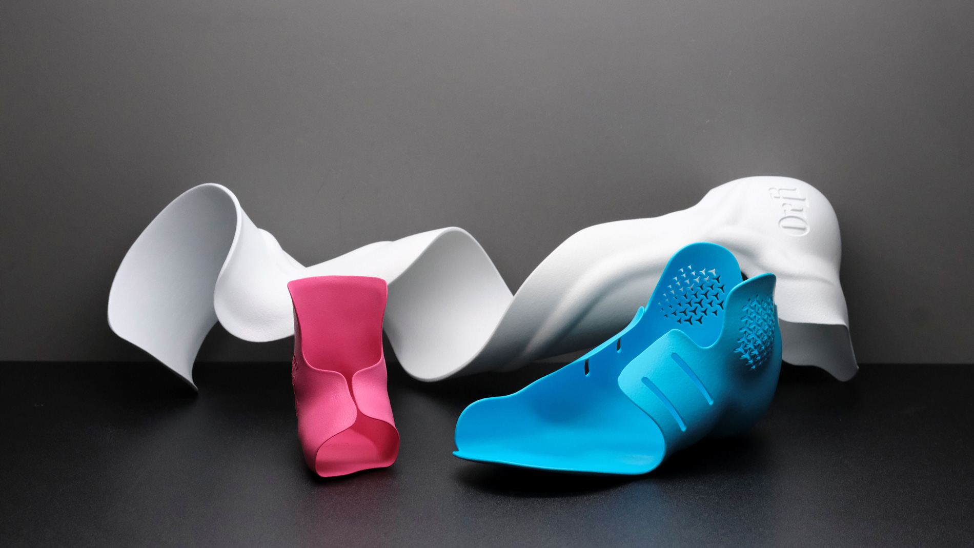 3D-gedruckte Knöchel- Fuß-Orthesen (AFO) von Orfi, die über Nowecor gedruckt wurden: hinten entpulvertes Rohteil, vorn gefinishte Teile mit Glättung und Färbung. Bild: Emil Wörgötter